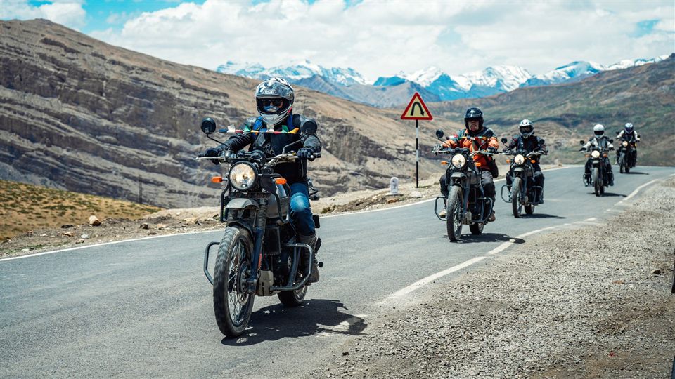 A group of motorcyclists riding together on a mountain road