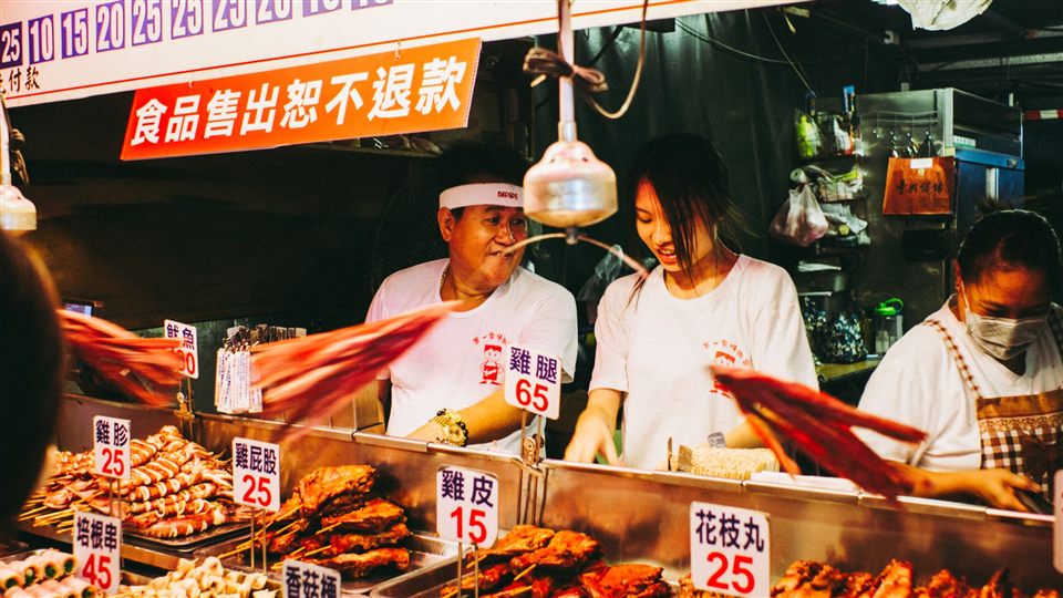 A food market stall in Asia with red signage